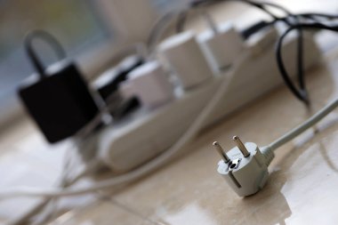 Aşırı yüklenmiş güç panoları. Beyaz zeminde farklı elektrik prizleri olan elektrik şeritleri. Risk tehlikesi kavramı elektrik akımını aşırı yükledi