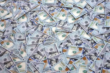 Çok büyük miktarlarda 100 dolarlık banknotlar kapanıyor. Düz tablonun üzerinde büyük miktarda Birleşik Devletler para birimi notu var.