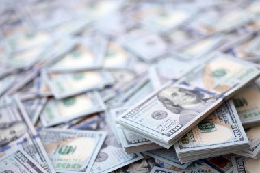 Çok büyük miktarlarda 100 dolarlık banknotlar kapanıyor. Düz tablonun üzerinde büyük miktarda Birleşik Devletler para birimi notu var.