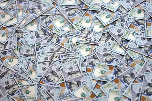 Çok büyük miktarlarda 100 dolarlık banknotlar kapanıyor. Düz tablonun üzerinde büyük miktarda Birleşik Devletler para birimi notu var.