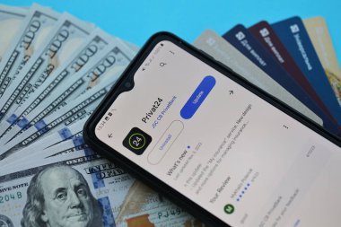 TERNOPİL, UKRAINE - 7 Temmuz 2023 Privatbank yeni bankacılık kartları ve masada para. Privat24 başvurusu kapat