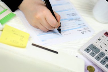 KYIV, UKRAINE - 31 Ekim 2023 Muhasebeci vergi döneminin sonunda İtalya 'nın vergi formunu doldurdu. İtalya 'da vergi ve evrak işleri rutini