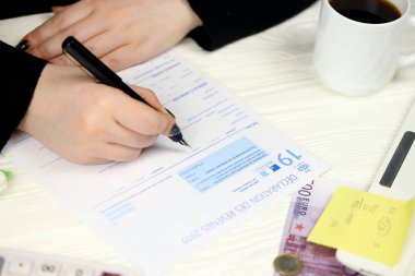 KYIV, UKRAINE - 31 Ekim 2023 Muhasebeci, vergi döneminin sonunda Fransız vergi formunu doldurdu. Fransa 'da vergilendirme ve evrak işleri