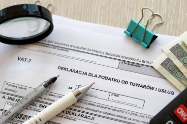 Mallara ve hizmetlere uygulanan vergi beyannamesi. Muhasebeci masasında KDV-7 formu. Kalem ve zloti paraları kapatıldı.