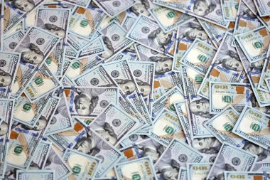 Çok büyük miktarlarda 100 dolarlık banknotlar kapanıyor. Düz tablonun üzerinde büyük miktarda Birleşik Devletler para birimi notu var.