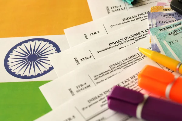 インドの所得税申告書は インドの国旗にペンとインドのルピーの請求書が閉じ込められた空白のフォームを返します 年次税務報告書のコンセプト — ストック写真