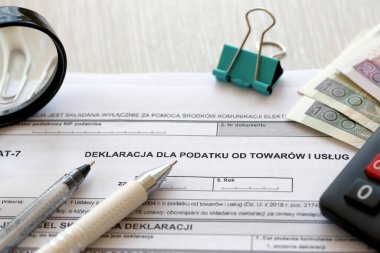Mallara ve hizmetlere uygulanan vergi beyannamesi. Muhasebeci masasında KDV-7 formu. Kalem ve zloti paraları kapatıldı.