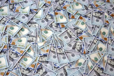 Çok büyük miktarlarda 100 dolarlık banknotlar kapanıyor. Düz tablonun üzerinde büyük miktarda Birleşik Devletler para birimi notu var.