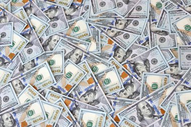 Çok büyük miktarlarda 100 dolarlık banknotlar kapanıyor. Düz tablonun üzerinde büyük miktarda Birleşik Devletler para birimi notu var.