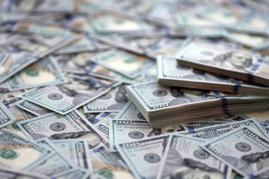 Çok büyük miktarlarda 100 dolarlık banknotlar kapanıyor. Düz tablonun üzerinde büyük miktarda Birleşik Devletler para birimi notu var.