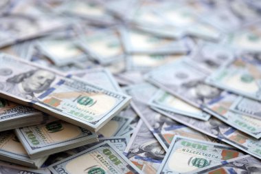 Çok büyük miktarlarda 100 dolarlık banknotlar kapanıyor. Düz tablonun üzerinde büyük miktarda Birleşik Devletler para birimi notu var.