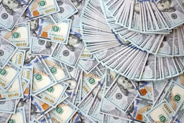 Çok büyük miktarlarda 100 dolarlık banknotlar kapanıyor. Düz tablonun üzerinde büyük miktarda Birleşik Devletler para birimi notu var.