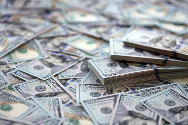 Очень большое количество банкнот в сто долларов. Огромное количество банкнот США на плоском столе