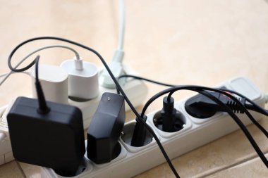 Aşırı yüklenmiş güç panoları. Beyaz zeminde farklı elektrik prizleri olan elektrik şeritleri. Risk tehlikesi kavramı elektrik akımını aşırı yükledi