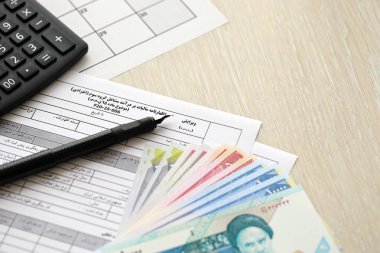 İran 'ın yıllık gelir vergi iade formu F20-25-006 kalem, hesap makinesi ve İran parasıyla doldurmaya hazır