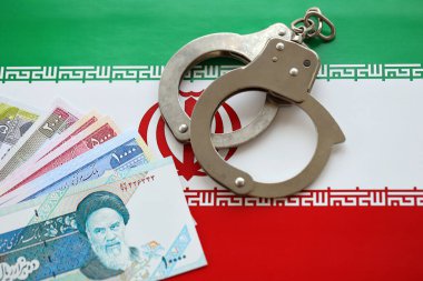 İran bayrağı ve polise kelepçelenmiş İran para senetleri. Ülkede suç ve suç kavramı