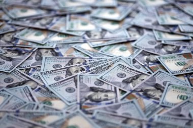 Çok büyük miktarlarda 100 dolarlık banknotlar kapanıyor. Düz tablonun üzerinde büyük miktarda Birleşik Devletler para birimi notu var.