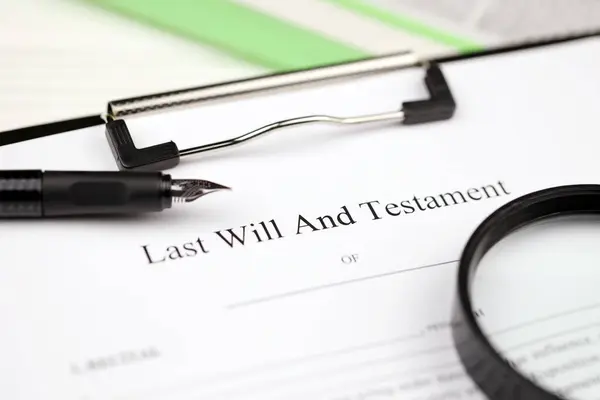 Last Will and testament blank document on A4 tablet lies on office table with pen and magnifying glass close up