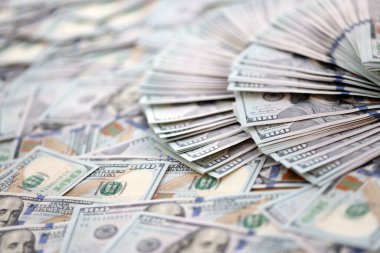 Çok büyük miktarlarda 100 dolarlık banknotlar kapanıyor. Düz tablonun üzerinde büyük miktarda Birleşik Devletler para birimi notu var.