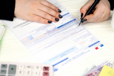 KYIV, UKRAINE - 31 Ekim 2023 Muhasebeci Fransız vergi formunu doldurdu 10963 Değer katma vergisi ve vergi döneminin sonunda benzer vergiler. Fransa 'da vergilendirme ve evrak işleri