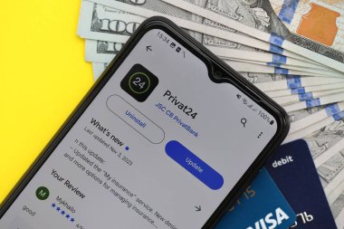 TERNOPİL, UKRAINE - 7 Temmuz 2023 Privatbank yeni bankacılık kartları ve masada para. Privat24 başvurusu kapat