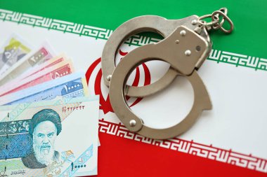 İran bayrağı ve polise kelepçelenmiş İran para senetleri. Ülkede suç ve suç kavramı