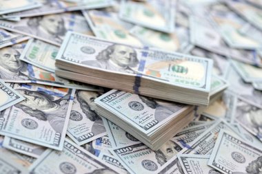 Çok büyük miktarlarda 100 dolarlık banknotlar kapanıyor. Düz tablonun üzerinde büyük miktarda Birleşik Devletler para birimi notu var.