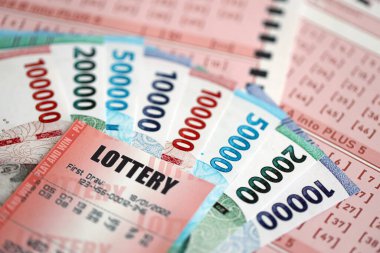 Kırmızı piyango bileti, Endonezya rupia parasıyla birlikte pembe kumar çarşaflarında yatıyor. Endonezya 'da piyango oynamak ya da kumar bağımlılığı