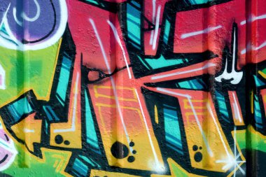 Duvarında parlak aerosol çizgileri olan grafiti resimlerinin renkli arka planı. Eski moda sokak sanatı sprey boya kutularından yapılmış. Çağdaş gençlik kültürü arka planı