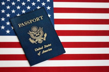Amerika Birleşik Devletleri 'nin yeni mavi pasaportu Amerikan Bayrağı arka planında. ABD vatandaşlığı alma kavramı