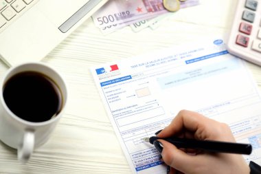 KYIV, UKRAINE - 31 Ekim 2023 Muhasebeci Fransız vergi formunu doldurdu 10963 Değer katma vergisi ve vergi döneminin sonunda benzer vergiler. Fransa 'da vergilendirme ve evrak işleri