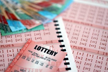 Kırmızı piyango bileti, Endonezya rupia parasıyla birlikte pembe kumar çarşaflarında yatıyor. Endonezya 'da piyango oynamak ya da kumar bağımlılığı