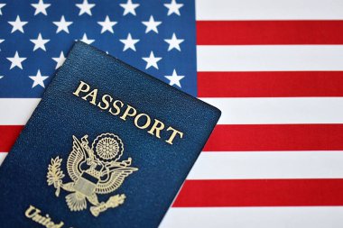 Amerika Birleşik Devletleri 'nin yeni mavi pasaportu Amerikan Bayrağı arka planında. ABD vatandaşlığı alma kavramı