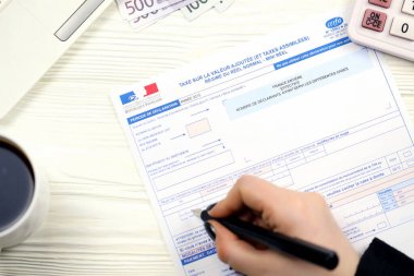 KYIV, UKRAINE - 31 Ekim 2023 Muhasebeci Fransız vergi formunu doldurdu 10963 Değer katma vergisi ve vergi döneminin sonunda benzer vergiler. Fransa 'da vergilendirme ve evrak işleri