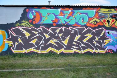 Sokak sanatı kültürü tarzında boya lekeleriyle süslenmiş eski duvar. Duvarında parlak aerosol çizgileri olan graffiti resimlerinin renkli arka planı. Renkli arkaplan dokusu