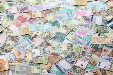 Farklı para birimlerinden bir sürü banknot. Rastgele para akışının arka planı kapanıyor.