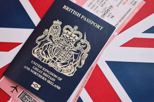 Ulusal arkaplanda uçak biletleri olan mavi İngiliz pasaportu. Turizm ve seyahat kavramı