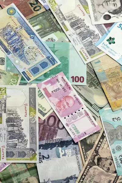 Farklı para birimlerinden bir sürü banknot. Rastgele para akışının arka planı kapanıyor.