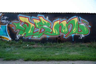 Sokak sanatı kültürü tarzında boya lekeleriyle süslenmiş eski duvar. Duvarında parlak aerosol çizgileri olan graffiti resimlerinin renkli arka planı. Renkli arkaplan dokusu