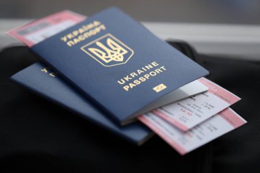 Siyah turistik sırt çantası üzerinde uçuş biletleri olan iki Ukrayna biyometrik pasaportu.