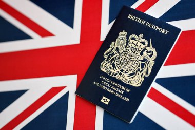 Ulusal arkaplanda mavi İngiliz pasaportu var. Yakın plan. Turizm ve vatandaşlık kavramı