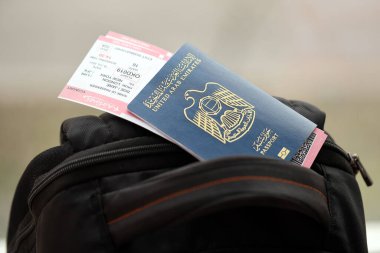 Mavi Birleşik Arap Emirlikleri pasaportu ve turistik sırt çantasında uçak biletleri. Turizm ve seyahat kavramı