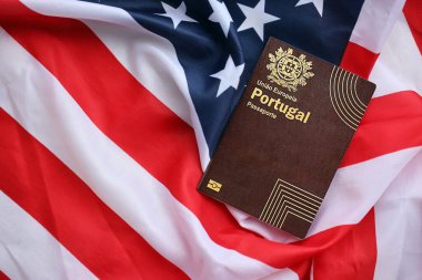 Avrupa Birliği 'nin kırmızı Portekiz pasaportu Amerika Birleşik Devletleri ulusal bayrağında yakın plan. Turizm ve diplomasi kavramı