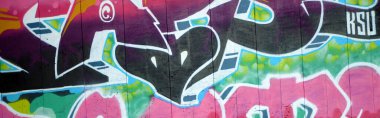 Duvarında parlak aerosol çizgileri olan grafiti resimlerinin renkli arka planı. Eski moda sokak sanatı sprey boya kutularından yapılmış. Çağdaş gençlik kültürü arka planı