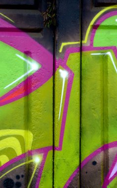 Duvarında parlak aerosol çizgileri olan grafiti resimlerinin renkli arka planı. Eski moda sokak sanatı sprey boya kutularından yapılmış. Çağdaş gençlik kültürü arka planı