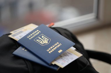 Siyah turistik sırt çantası üzerinde uçuş biletleri olan iki Ukrayna biyometrik pasaportu.