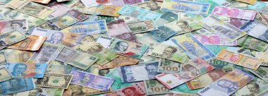 Farklı para birimlerinden bir sürü banknot. Rastgele para akışının arka planı kapanıyor.