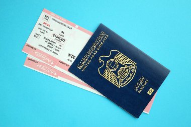Mavi arka planda uçak biletleri olan Mavi Birleşik Arap Emirlikleri pasaportu. Turizm ve seyahat kavramı