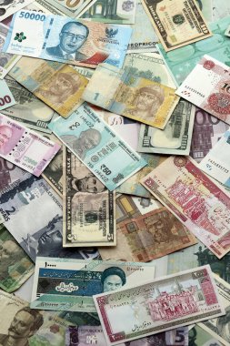 Farklı para birimlerinden bir sürü banknot. Rastgele para akışının arka planı kapanıyor.