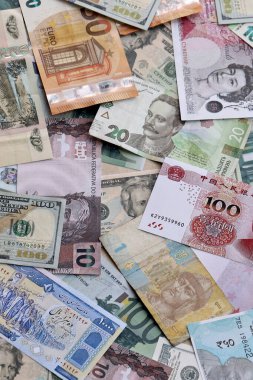 Farklı para birimlerinden bir sürü banknot. Rastgele para akışının arka planı kapanıyor.